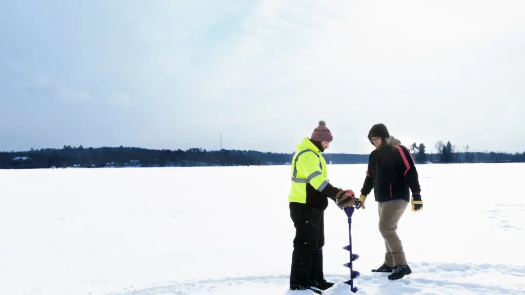 two people setting up for ice fishing